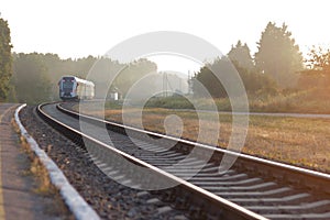 Train leaving the station on foggy morning. Industrial landscape