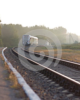 Train leaving the station on foggy morning. Industrial landscape