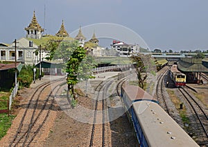 A train is leaving the Yangon Central Railway Station on the railway tracks