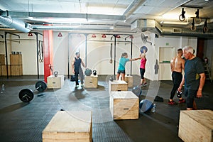 Train with like minded fitness fanatics. a group of people working out at the gym.