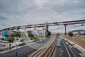 AlcÃ¢ntara, Lisbon PORTUGAL - May 29, 2022 - Train line between roads and 25th of April bridge in the background