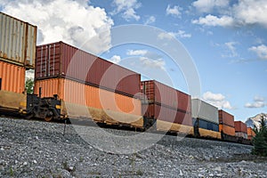Train long freight passing with container loading on railway in valley