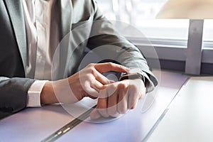 In the train a man using his smartwatch. Close-up hands