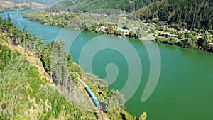 Train mooving through the forest, wineries alonong the banks of Maule river near Constitucion in Chile