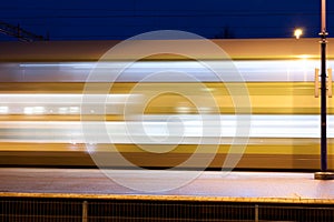 Train in motion on the station at night, long exposure photo