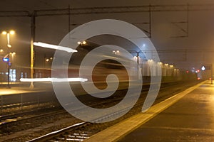 Train in motion on the station at night, long exposure photo