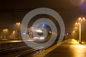 Train in motion on the station at night, long exposure photo