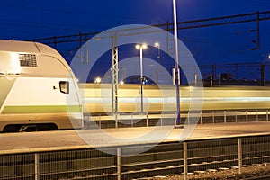 Train in motion on the station at night, long exposure photo