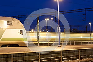 Train in motion on the station at night, long exposure photo