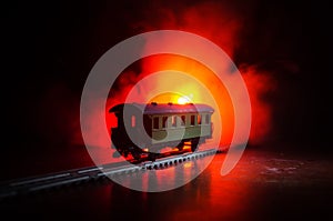 Train moving in fog. Ancient steam locomotive in night. Night train moving on railroad. orange fire background.