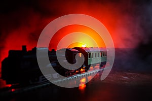 Train moving in fog. Ancient steam locomotive in night. Night train moving on railroad. orange fire background.