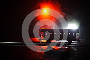 Train moving in fog. Ancient steam locomotive in night. Night train moving on railroad. orange fire background.