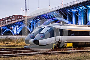 Train Paring under lit bridge