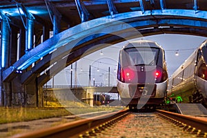 Train Paring under lit bridge