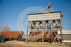 Train is parked next to building with lot of rust