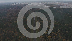 The train passes through the forest towards the city. aerial view.fog or mist.