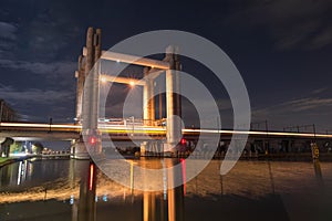 Train passes by at high speed on a railway lifting bridge over a river in Holland