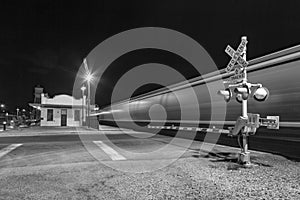 Train passes at railroad crossing in the night. The Kingman station of the Santa Fee railroad opened in 1907 and is still in use