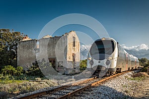 Train passing derelict station at Lumio in Corsica