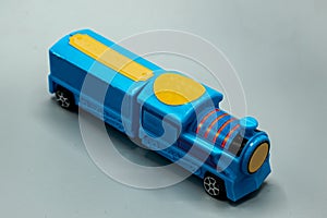 train. plastic train toy. blue train with cargo on gray background