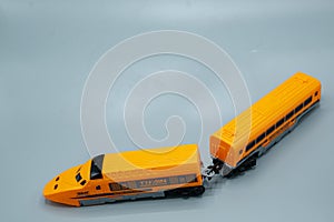 train. plastic train toy. yellow train with passenger car on gray background.