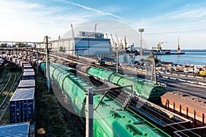 A train is pulling into a station with a large building in the background