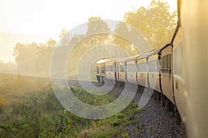 Train on Railroad track during autumn foggy morning in countrysi