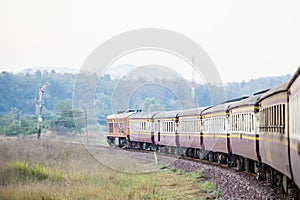 Train on Railroad track during autumn foggy morning in countryside.