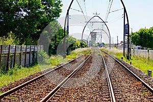 Train rails in country and electric poles arch