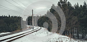 Train rails in winter season. Beautiful landscape of countryside. Rail track laid through forest