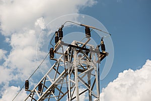 Train or railway power line support. Railway power lines with high voltage electricity on metal poles against blue sky.