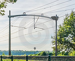 Train railway with a stork bird nest and power cables
