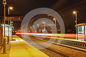 Train with red light on long exposure in station at night scene.