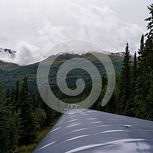 Train running along the Alaska Range in the Southcentral region of Alaska, USA under a cloudy sky photo