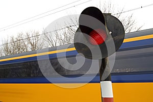 Train rushing past railway crossing photo