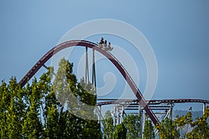 The train with some people is riding on roller coaster during a cloudy weather