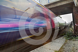 Train speeding in blur under bridge