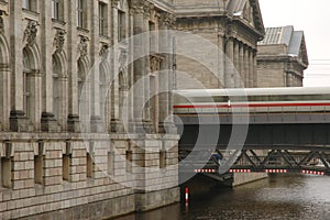 Train speeding between large museum buildings