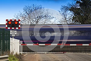 Train speeding through a level crossing