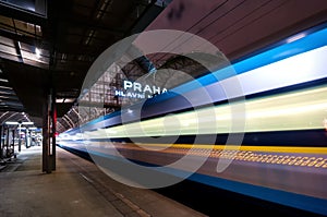 Train speeding through railway station with extended motion.