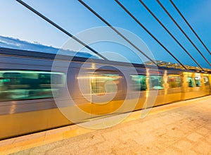 Train speeding up on a station at night. Blurred motion effect