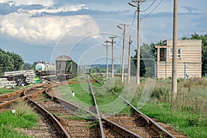 Train standing on siding on a sunny day in summer. Railway freight wagons and tanks of a different type and color