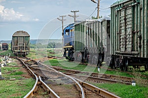 Train standing on siding on a sunny day in summer. Railway freight wagons and tanks of a different type and color