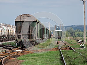 Train standing on siding on a sunny day in summer. Railway freight wagons and tanks of a different type and color