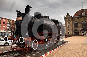 Train station with old locomotive in front of building in Arad