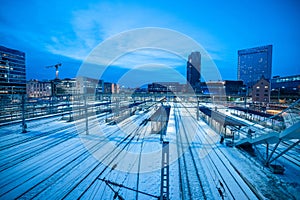 Train station of Oslo seen from one of the overpasses from the bus station. Many tracks seen leading into the station, surrounded