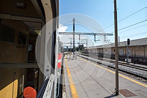 Train station platform of Pivka, slovenia, seen from the window of a passenger train travelling accross europe during sunny summer photo