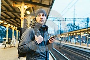 Train Station in Sopot, Poland, Europe. Attractive man waiting at the train station. Thinking about trip, with backpack. Travel