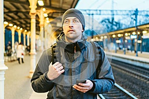 Train Station in Sopot, Poland, Europe. Attractive man waiting at the train station. Thinking about trip, with backpack. Travel