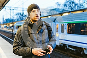 Train Station in Sopot, Poland, Europe. Attractive man waiting at the train station. Thinking about trip, with backpack. Travel